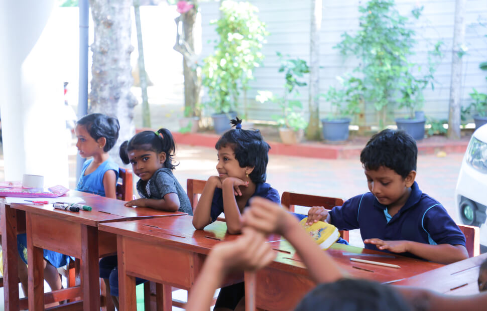 A group of Sri Lankan students in uniforms smiling in a classroom setting. Being BrightNest School