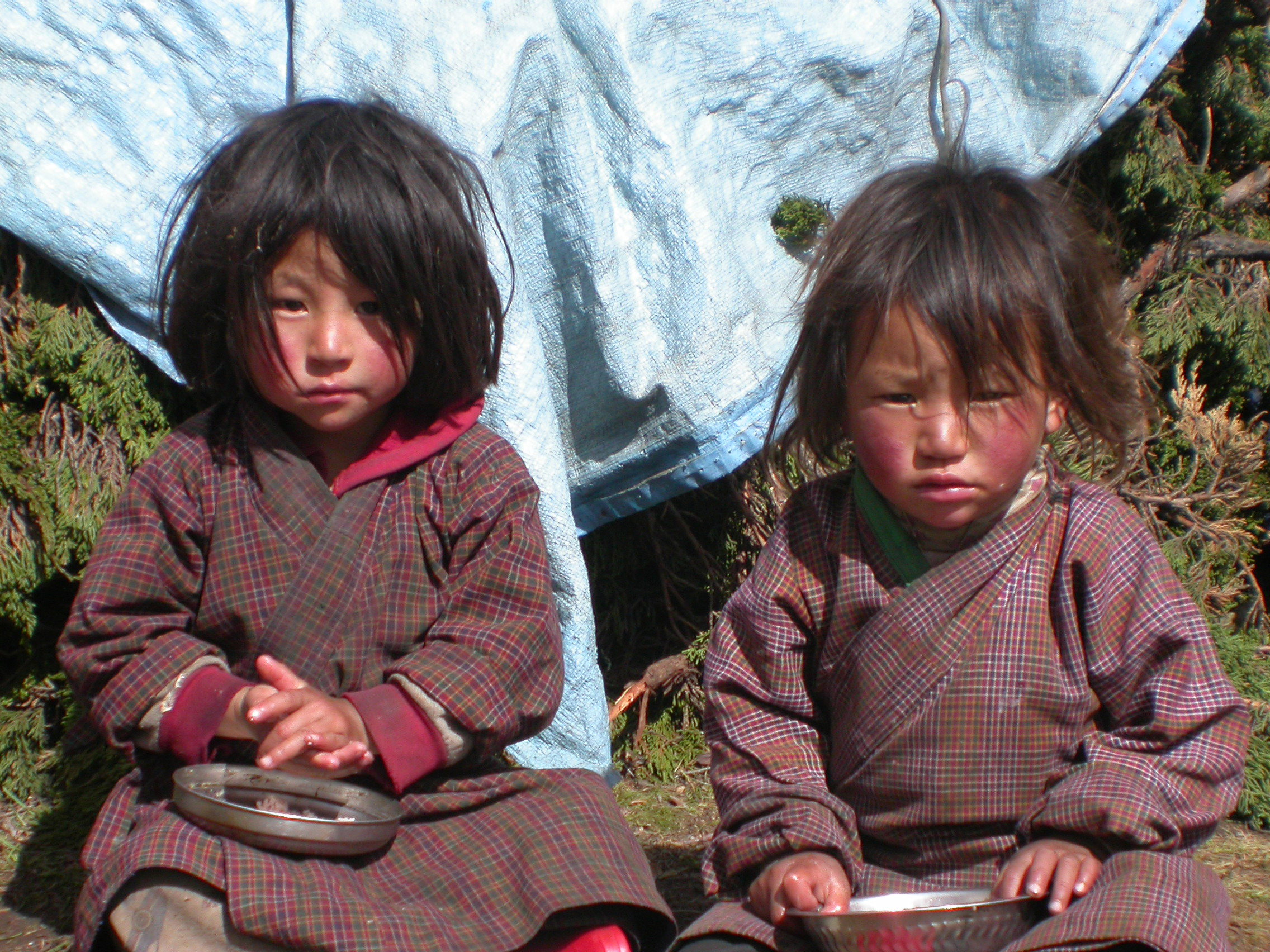 Children in Bhutan smiling and playing outdoors, highlighting UNICEF's impact on child poverty.