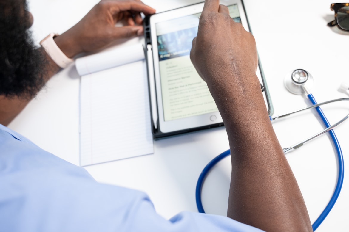 Man using a tablet in a bright room, Innovate Health Africa initiative. DHLSAT