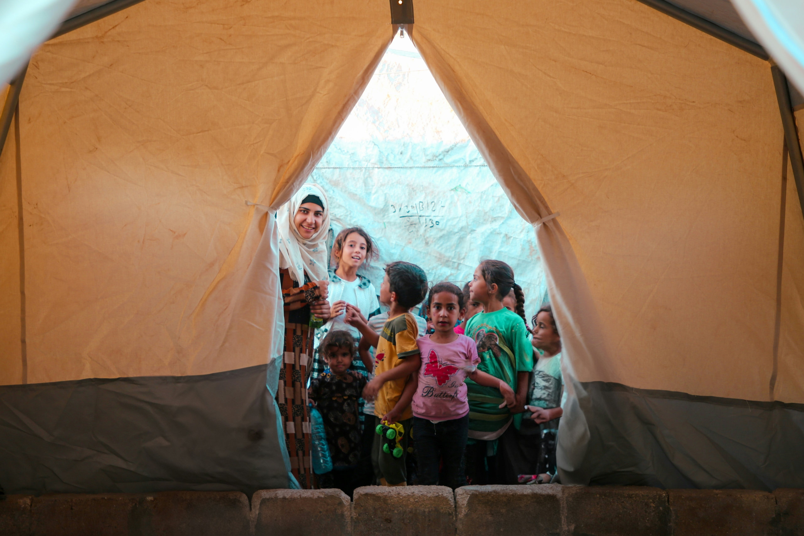A diverse group inside a large tent, symbolizing DREAMS for refugees' community focus.