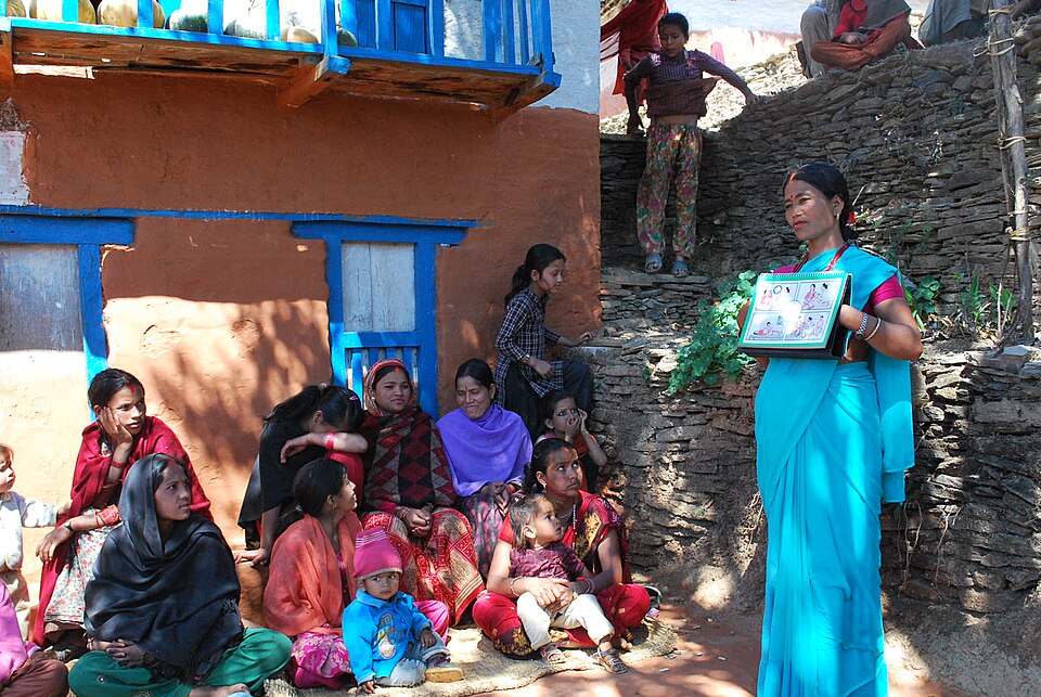Female health volunteer in Nepal educates pregnant women on antenatal care.