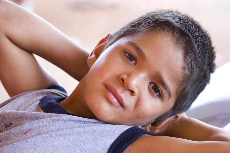 Young Brazilian child smiling, representing childhood poverty in Brazil and resilience.
