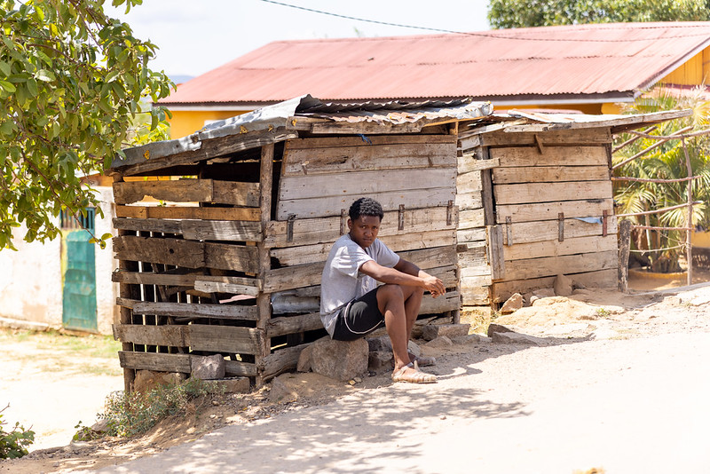 Children playing in a dusty street surrounded by makeshift homes, illustrating poverty in Madagascar.