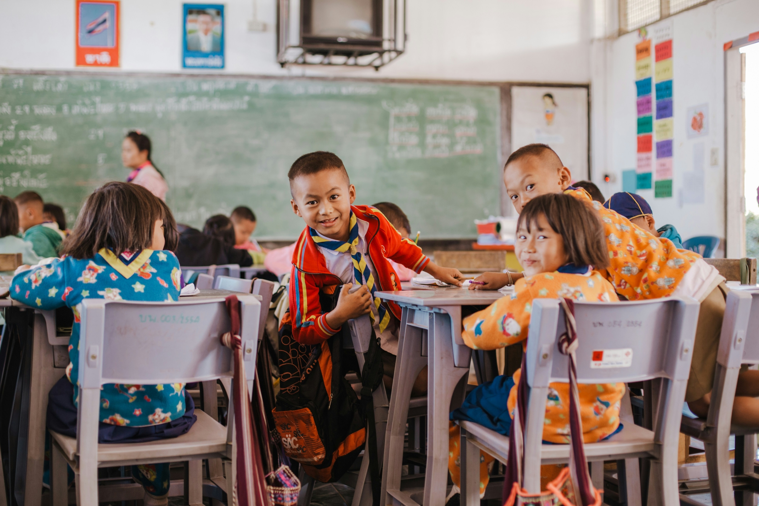 Children sitting attentively at desks in a classroom, part of Thailand's Zero Dropout Initiative.
