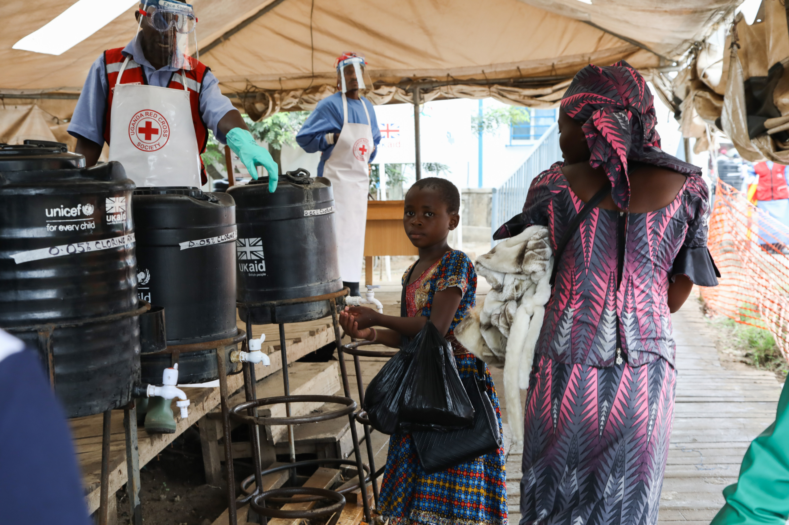 A woman in a rural village carries water, highlighting poverty challenges. U.K. foreign aid cuts