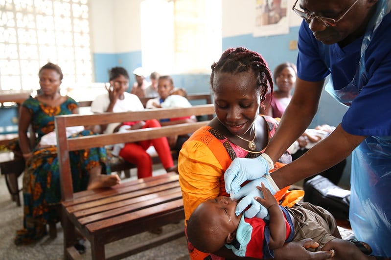 A health worker providing care to a child during a vaccination programme