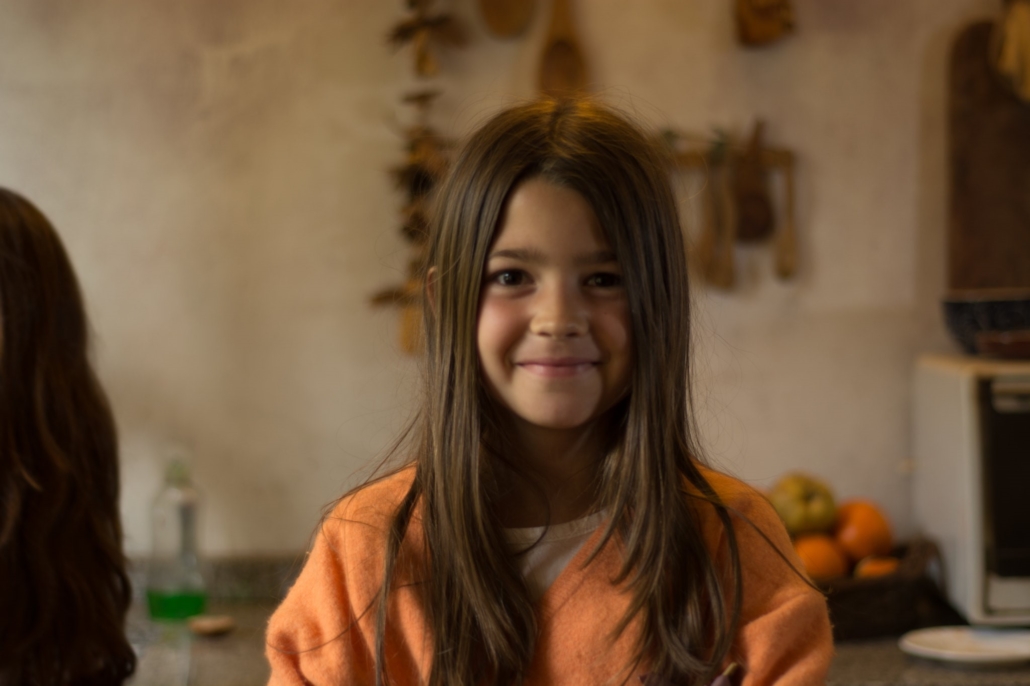 Disability and Poverty in Argentina. Little girl with long brown hair and wearing an orange sweater.